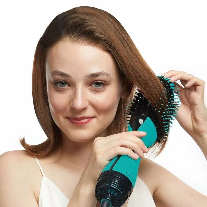 A model using a blue hot air brush to style their hair.