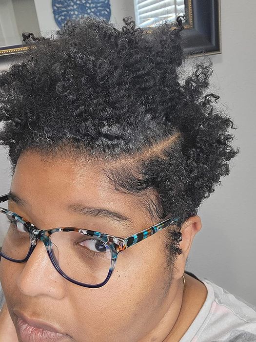 image of a reviewer with short, defined coils