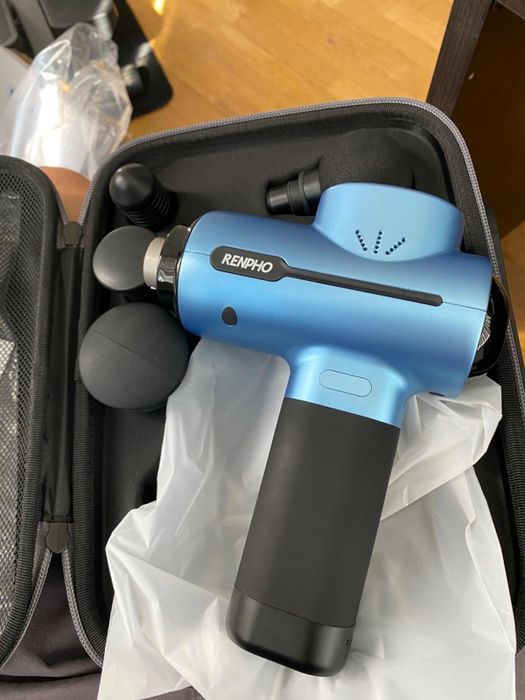 A reviewer’s photo of the massage gun in a blue color variant.