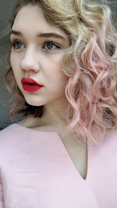 A picture showing the same Mytour editor, now with the lower part of her hair dyed a vibrant pink.