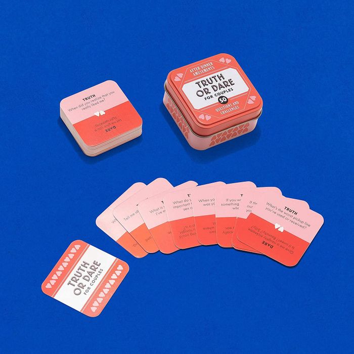 A tin container surrounded by cards.