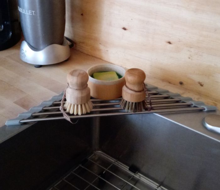 A reviewer’s bamboo brush and dish soap set resting on a sink