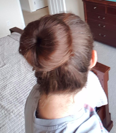 The bun shaper is securely positioned, looking flawless in someone's hair.