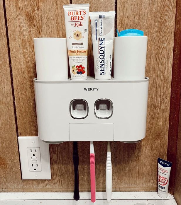 The white wall-mounted toothbrush holder in use