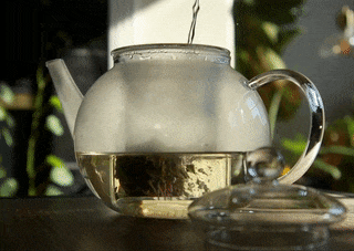 A GIF showing the reviewer pouring hot water over a blooming tea flower.