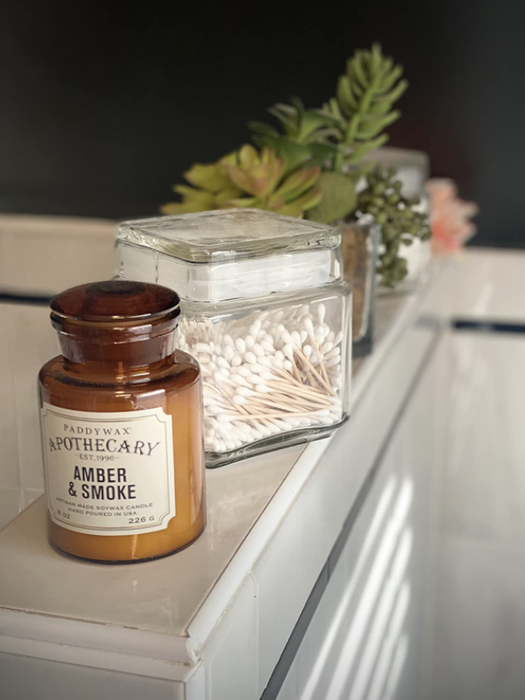 A reviewer’s candle resting on a bathroom counter