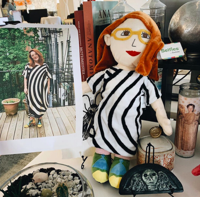 A doll version of me, wearing glasses, a striped dress, and colorful shoes that match the photo I sent.
