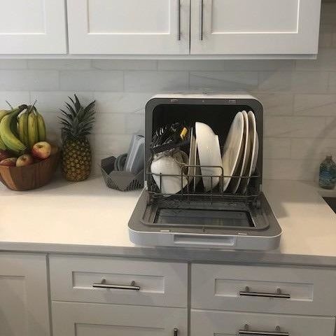 The dishwasher opened, revealing the clean dishes inside