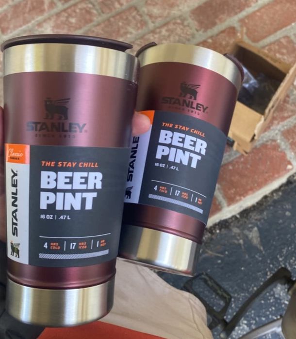 A reviewer enjoying two pints, each held in one hand.