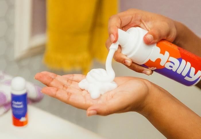 A hand with foaming dye in the palm, ready to apply.
