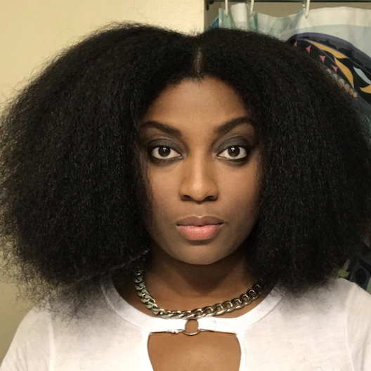 A woman sporting a shoulder-length afro hairstyle.