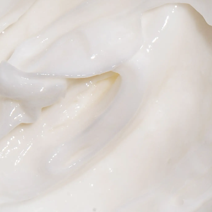 A close-up reveals the thick, white consistency of the hair mask.