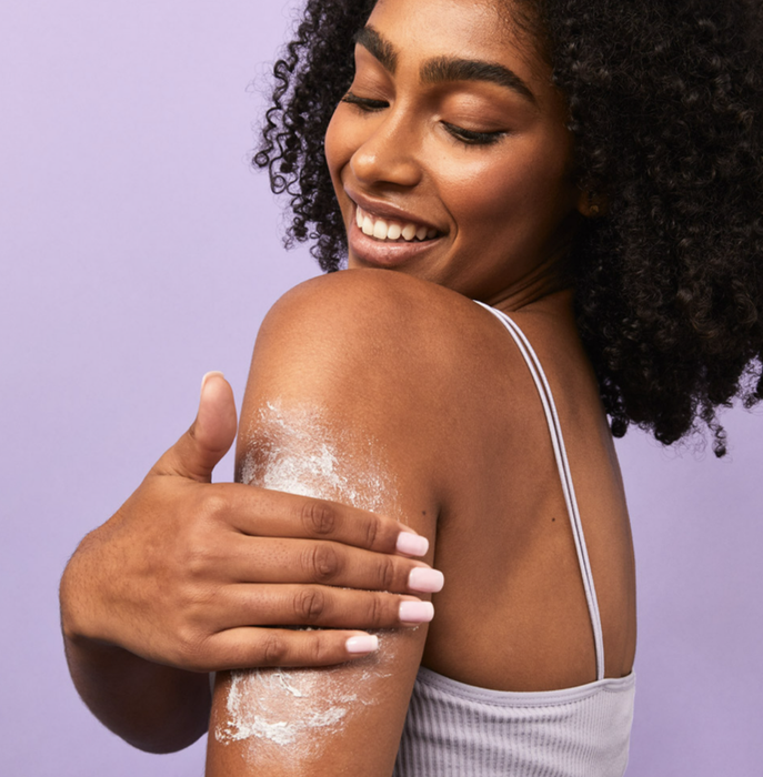 A model massaging the exfoliator into their arm.