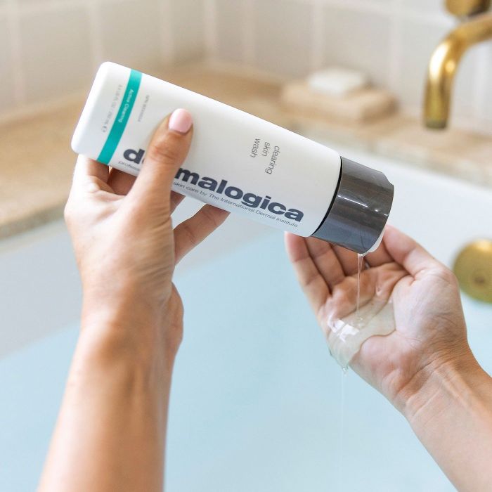 A model dispensing Dermalogica Special Cleansing Gel into their palm above a bathtub.