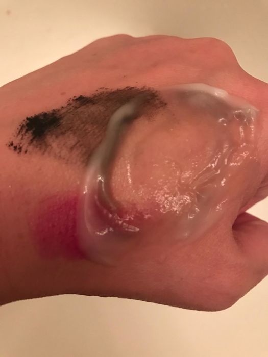 A reviewer demonstrating how effortlessly the cleanser removes makeup.