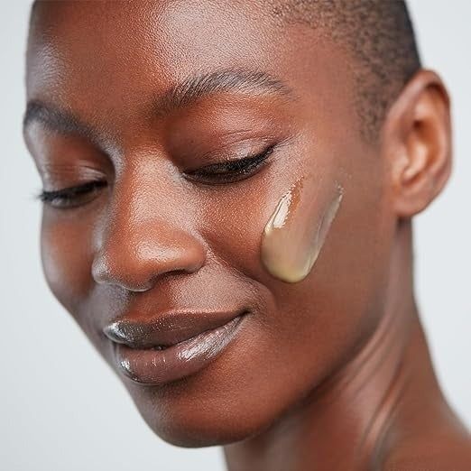 A model demonstrates the cleanser applied to their face.
