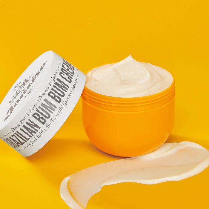An open tub of Brazilian Bum Bum Cream with a product swatch on the side.