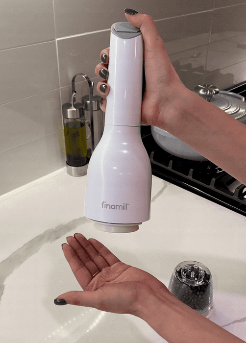 A gif of the grinder effortlessly grinding salt with just a single click of a button.