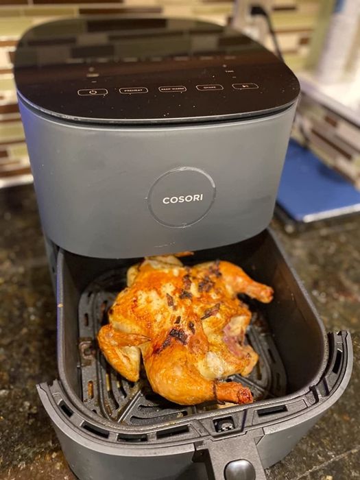 A different reviewer showing a perfectly cooked chicken in the gray air fryer