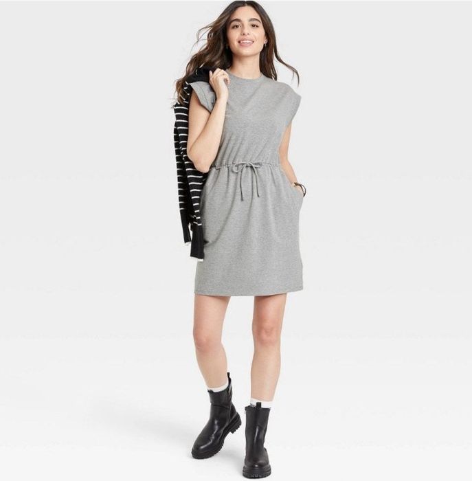 A model in a grey sleeveless dress