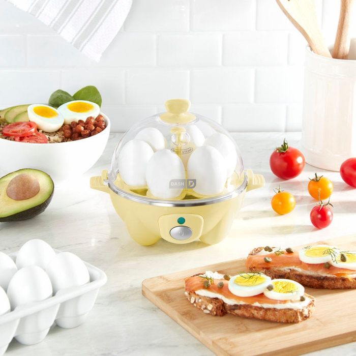 A kitchen scene featuring an egg cooker, eggs, avocado, tomatoes, and a plate of prepared egg toast. Perfect for a shopping article on kitchen gadgets.