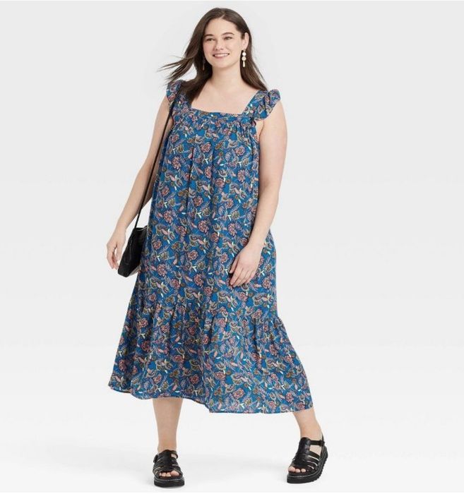 A model is wearing a beautiful blue floral midi dress.