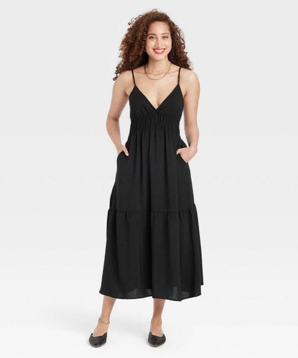 A model wearing a sleek black midi dress.
