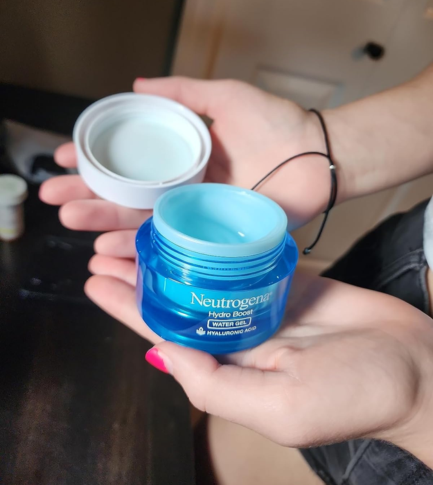A reviewer holding the open jar of the gel