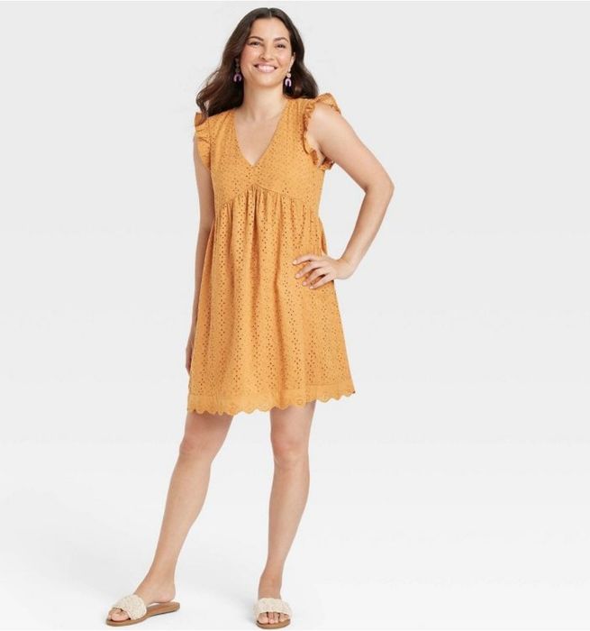 A model is wearing a stunning amber eyelet dress.