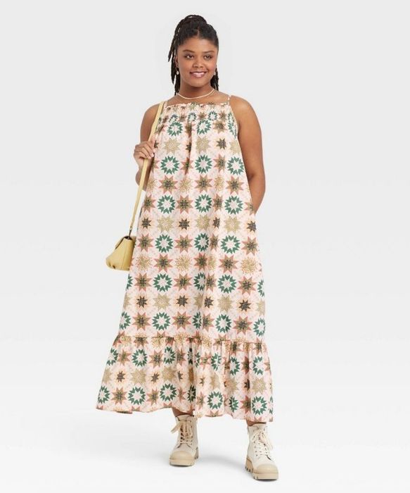 A model wearing a colorful, printed sleeveless tiered dress.