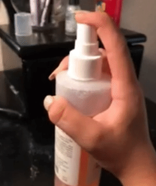 A GIF of a reviewer pressing the spray nozzle on the face mist bottle