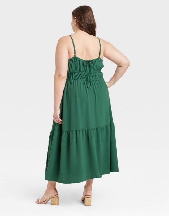 A model wearing a stylish green midi dress.
