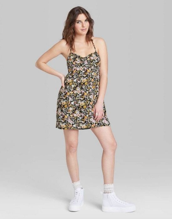 A model wearing a vibrant floral mini dress, radiating a playful and chic vibe.