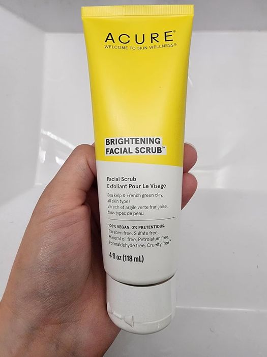 A reviewer holding a bottle of the scrub