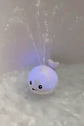 A reviewer’s GIF showing the whale bath toy in action, lighting up and squirting water