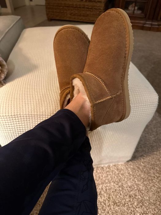 The reviewer is seen wearing the stylish brown mini boots, which are perfect for the colder season.