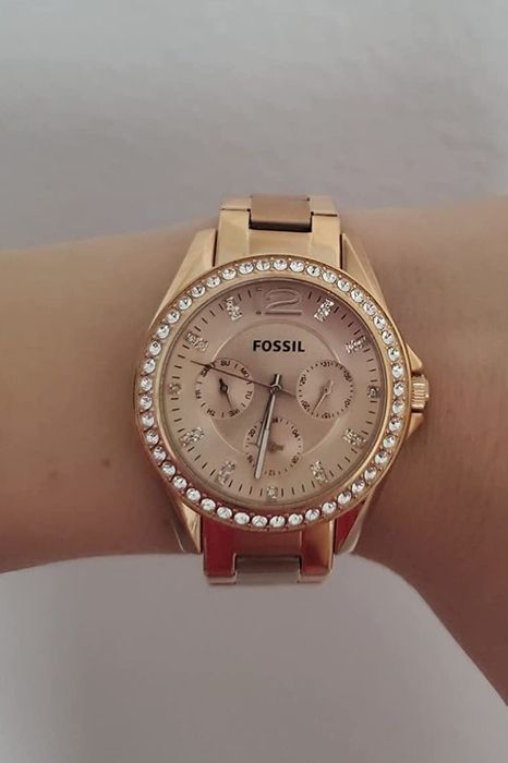 A reviewer displaying the exquisite rose gold Fossil watch, perfect for adding a touch of luxury to any outfit.
