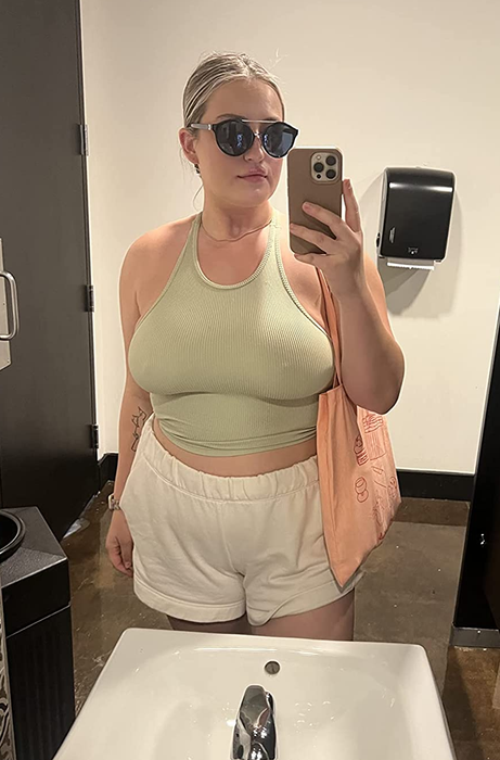 A reviewer models the olive green tank top.