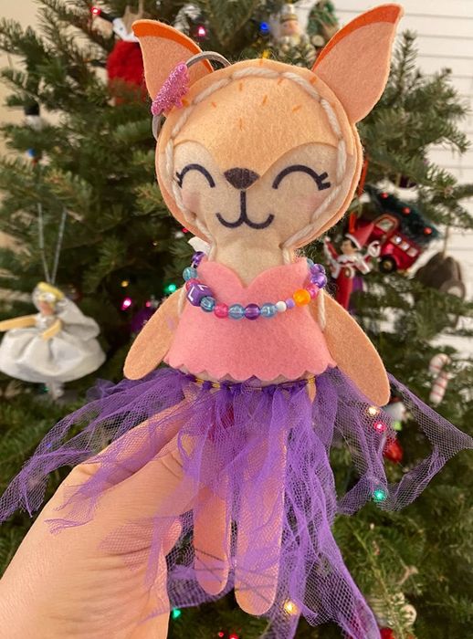 The completed fox, dressed in a purple tutu, beaded necklace, and a pink top with a scalloped hem