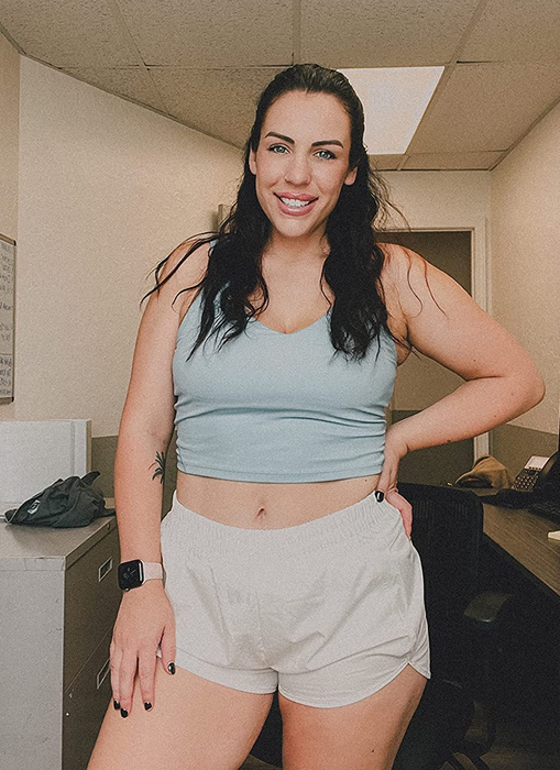 A reviewer models the white running shorts.