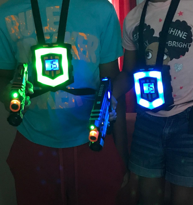 A reviewer’s image showing two kids wearing laser tag vests and holding laser guns