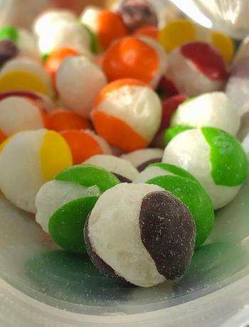 A close-up shot of the Skittles showing the texture after being freeze-dried and split apart
