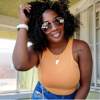 Reviewer in an orange halter top tucked into jeans