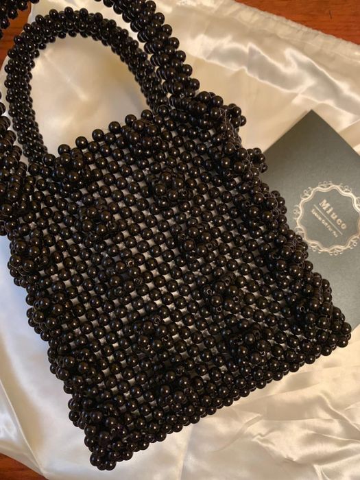 A close-up view of the black version of the beaded handbag, highlighting its intricate design.