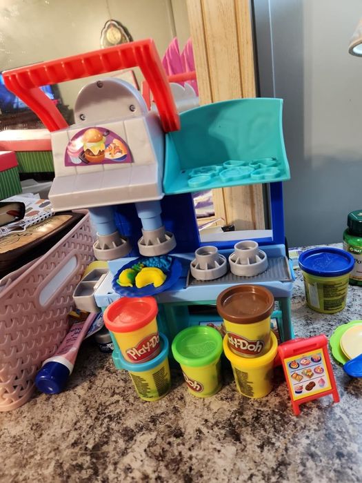 A Play-Doh ice cream playset with containers and accessories neatly arranged on a counter