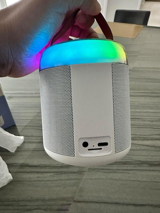 A portable Bluetooth speaker featuring a handle and a light-up function. Ideal for those searching for a multifunctional, color-changing audio gadget.