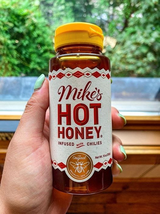 A reviewer proudly holding a bottle in hand.