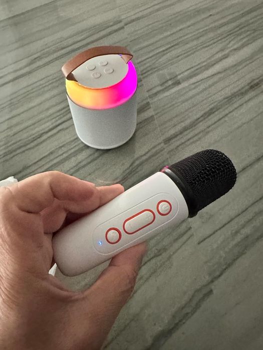 A portable Bluetooth karaoke microphone and speaker placed on a table, perfect for music lovers and lively gatherings.