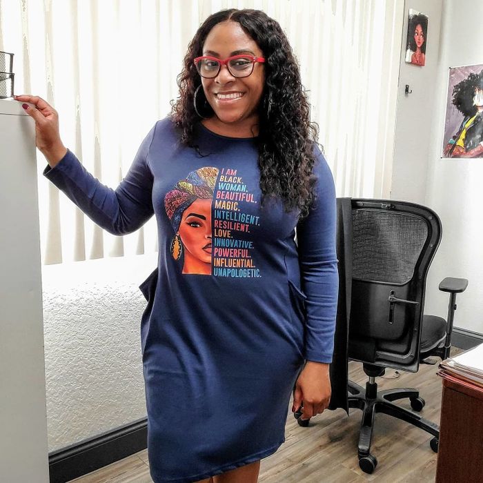 A reviewer looking stylish in a blue tunic dress with an eye-catching print.