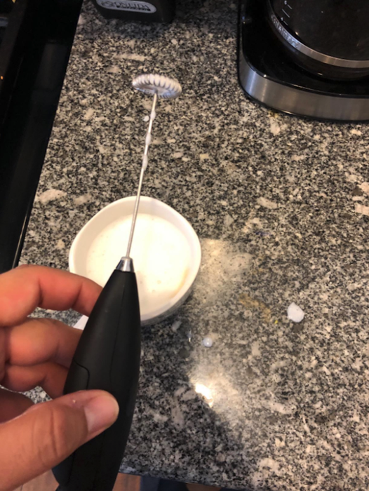 reviewer holding the milk frother